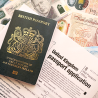 UK passport with application and pound notes underneath it