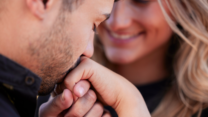 Man kissing woman on the hand