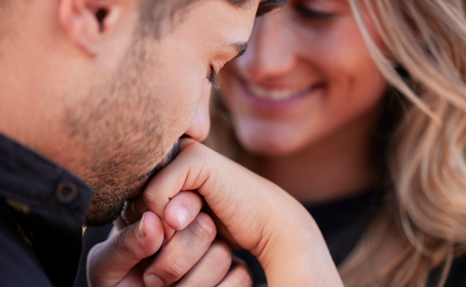 Man kissing woman on the hand
