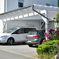 Carport in front of a house with 2 cars parked underneath