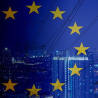 European Union flag over city skyline with power lines representing electricity and energy supply in Europe