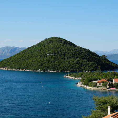Body of water with a view of a green hill