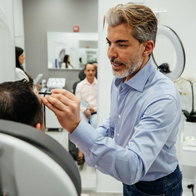Dr Serkan Aygin with a patient conducting hair transplant treatment