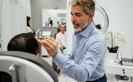 Dr Serkan Aygin with a patient conducting hair transplant treatment