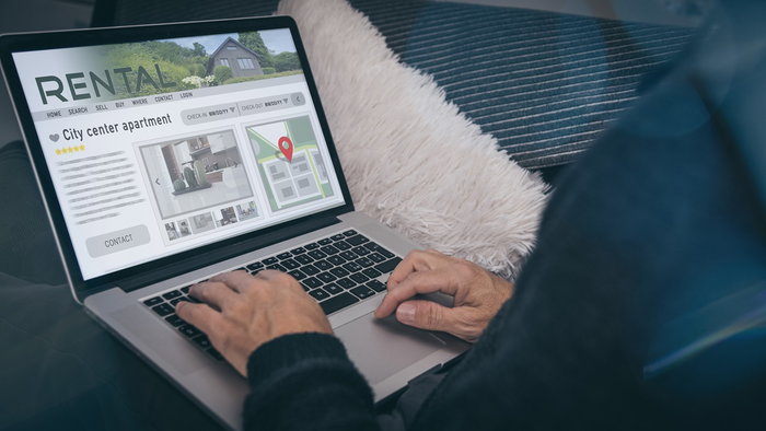 Person browsing a holiday rental listing on a laptop, checking apartment details online