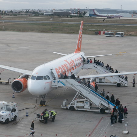 Passengers boarding an easyJet plane on the runway at a Spanish airport