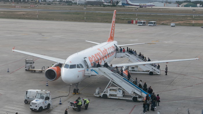 Passengers boarding an easyJet plane on the runway at a Spanish airport