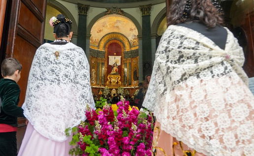 Young girls in traditional dress taking part in a floral offering in Cartagena