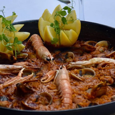 Seafood paella with rice, prawns and shellfish served by the coast in Murcia