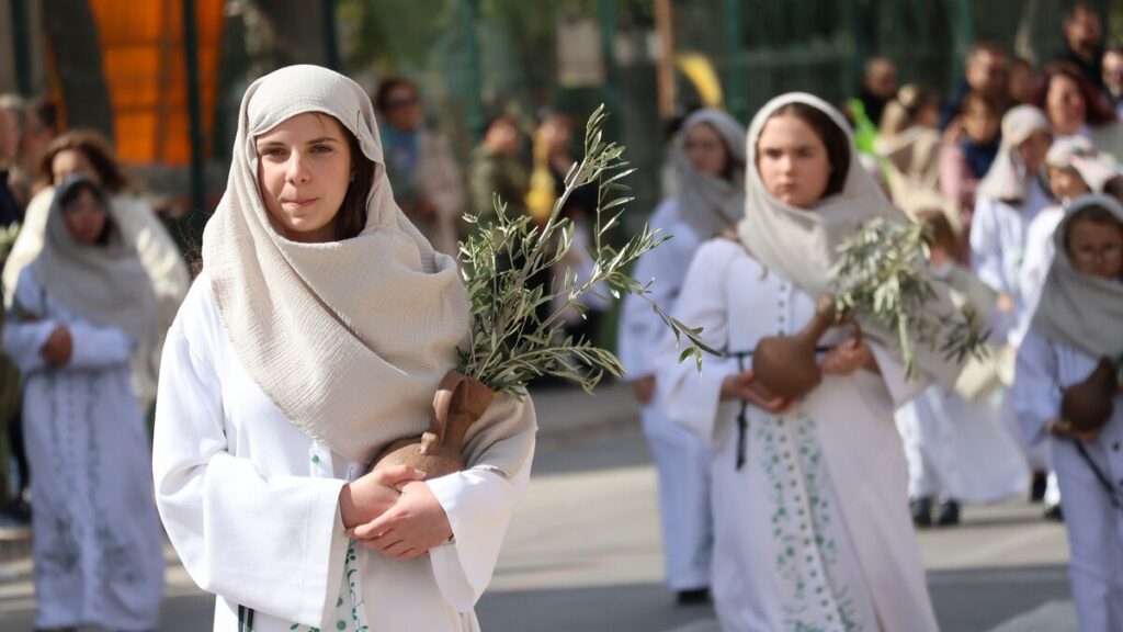 Children holding olive branches during Palm Sunday procession in San Pedro del Pinatar