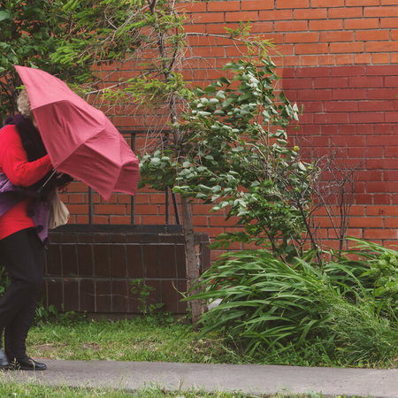 People struggling to walk through strong winds on a Spanish city street during weather alert