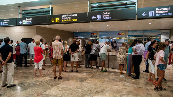 Passengers inside Alicante-Elche airport terminal during busy travel period