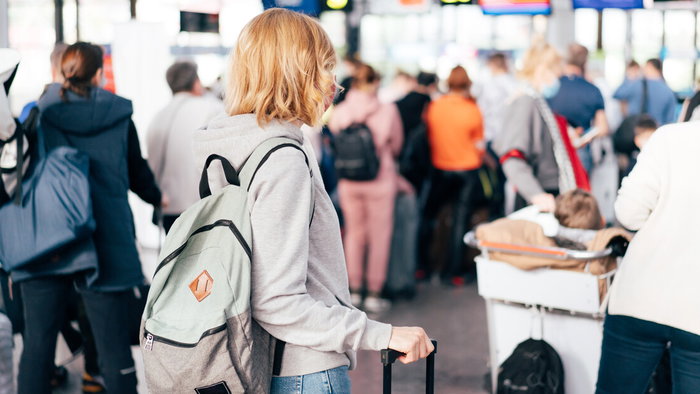 Travellers walking through a busy airport terminal during Easter holiday travel season