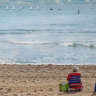 People sunbathing on a beach in Alicante during warm March weather