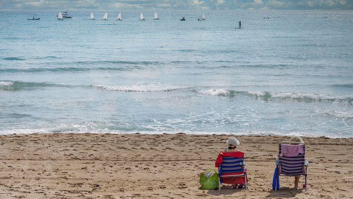 People sunbathing on a beach in Alicante during warm March weather