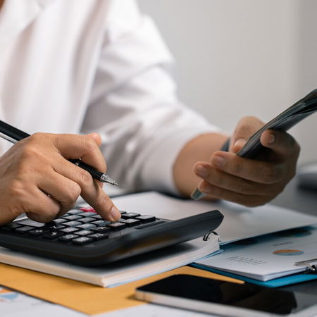 Person using a calculator to manage expenses in Spain despite rising average salaries