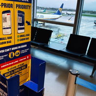 Ryanair staff checking passenger cabin luggage for extra items at boarding