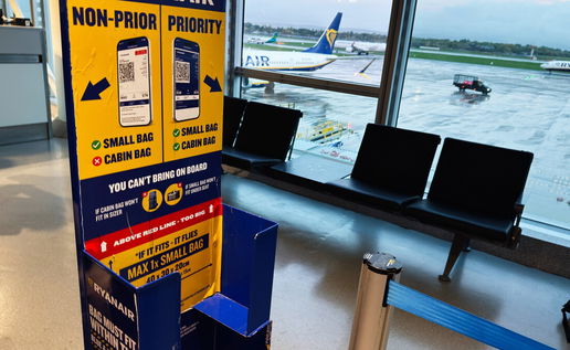 Ryanair staff checking passenger cabin luggage for extra items at boarding