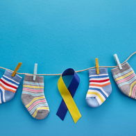 World Down syndrome day background. Down syndrome awareness concept. Socks and ribbon on blue background