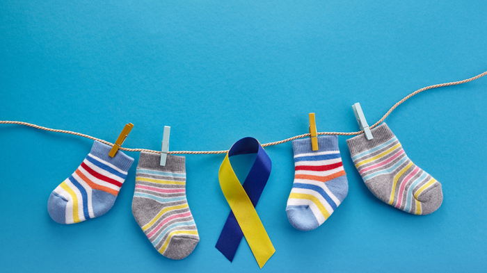World Down syndrome day background. Down syndrome awareness concept. Socks and ribbon on blue background