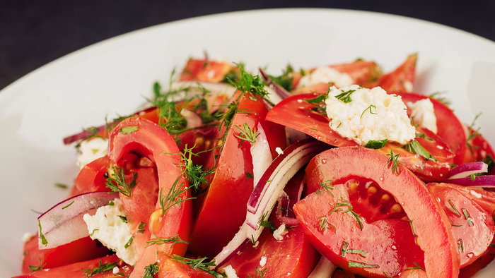 Salad with tomato, cheese, red onion, olive oil.