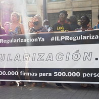 Protest in Spain calling for migrant regularisation with banner reading “Regularización Ya”