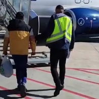 Man being accompanied to departing flight.