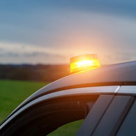 V16 emergency warning light flashing on top of a car stopped on the roadside in Spain.