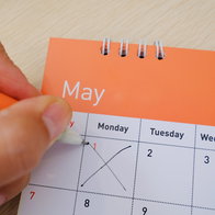 Hand marking 1 May on a calendar to highlight Spain public holiday dates