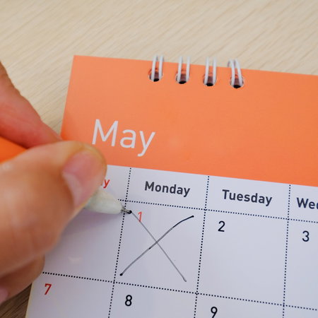 Hand marking 1 May on a calendar to highlight Spain public holiday dates