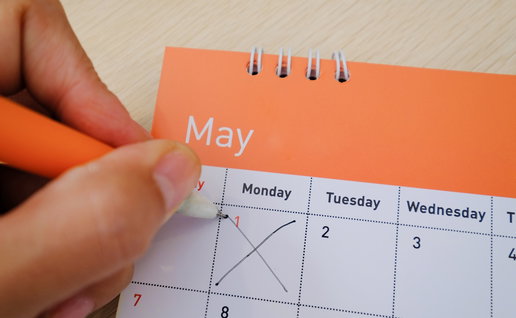 Hand marking 1 May on a calendar to highlight Spain public holiday dates