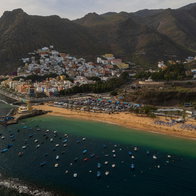 Aerial view of Playa de Las Teresitas in Tenerife, featuring golden sand, moored boats, and the San Andrés village.