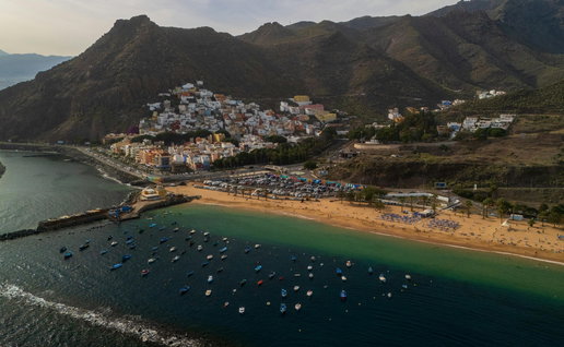 Aerial view of Playa de Las Teresitas in Tenerife, featuring golden sand, moored boats, and the San Andrés village.