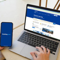 Person using Booking website on laptop and smartphone