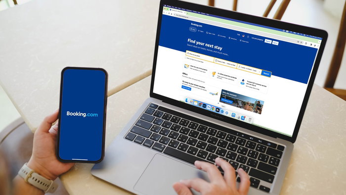 Person using Booking website on laptop and smartphone