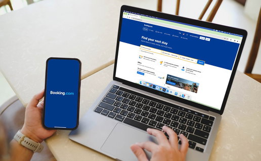 Person using Booking website on laptop and smartphone