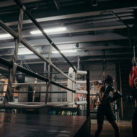 oung woman training at a boxing club using the bag