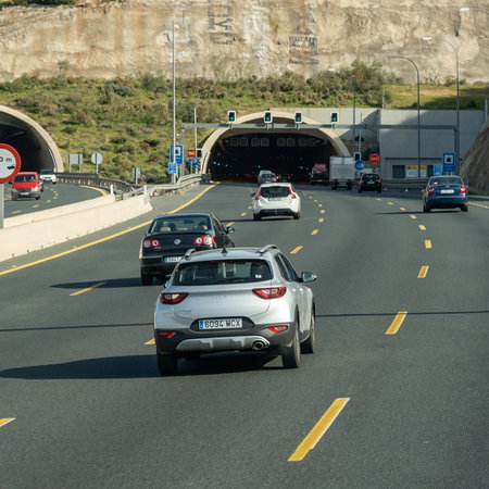 Cars driving towards a multi lane tunnel on a Spanish highway