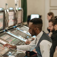 Black person sitting a the slot machines in a casino
