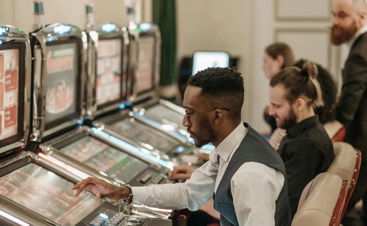 Black person sitting a the slot machines in a casino