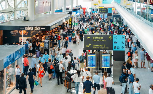Busy airport terminal in Portugal with long queues of passengers during peak travel period
