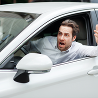 Stressed man looking out the window of his car