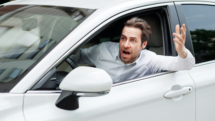 Stressed man looking out the window of his car