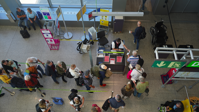 People queuing at a check in point at an airport
