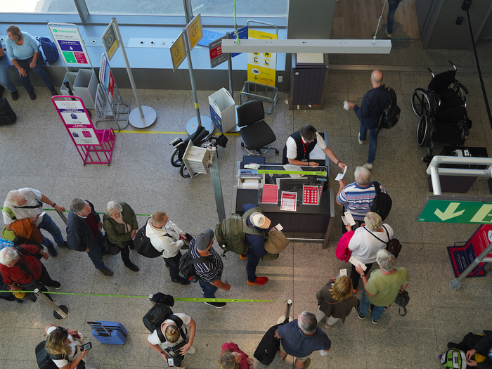 People queuing at a check in point at an airport