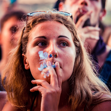 Young woman smoking a cigarette at a festival