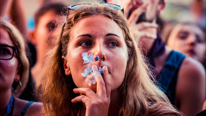 Young woman smoking a cigarette at a festival