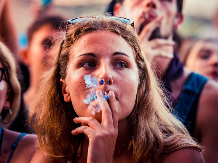 Young woman smoking a cigarette at a festival