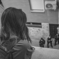 Girl on a balcony looking down at police offices