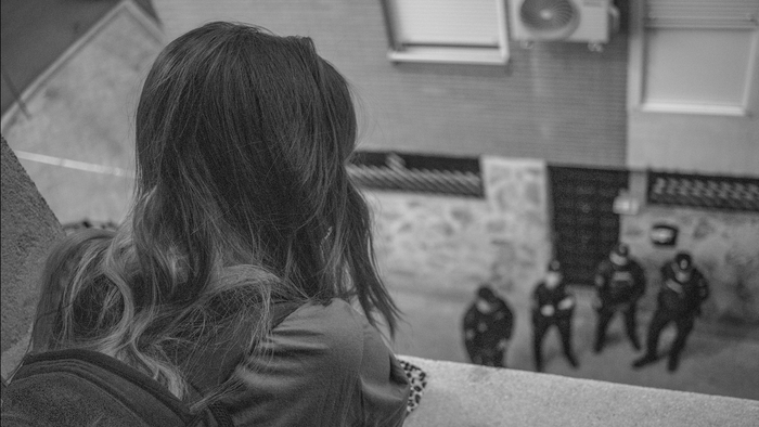 Girl on a balcony looking down at police offices